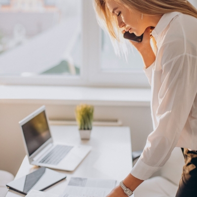Young business woman using phone in office